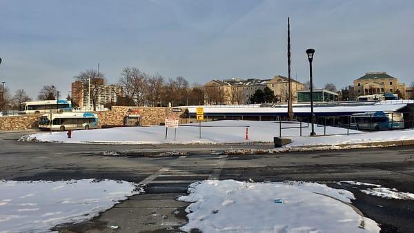 The exterior of the NFTA Metro Rails University Station, showing the bus loop and the 150-foot needlelike sculpture ( Vertical