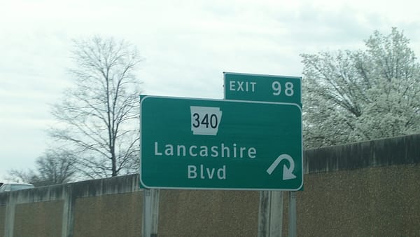 A roadside sign marking the junction of Arkansas Highway 340 with US Route 71, seen against open country