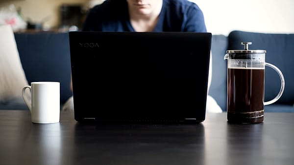 Coffee table as a desk - working from home with a coffee and a laptop