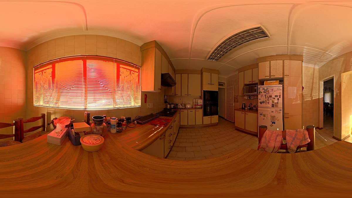 A wide view of a domestic kitchen, with counters, cabinets and a window along the far wall